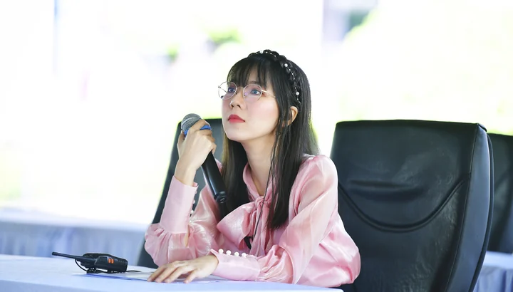 Christy working with a microphone and radio, wearing a pink blouse