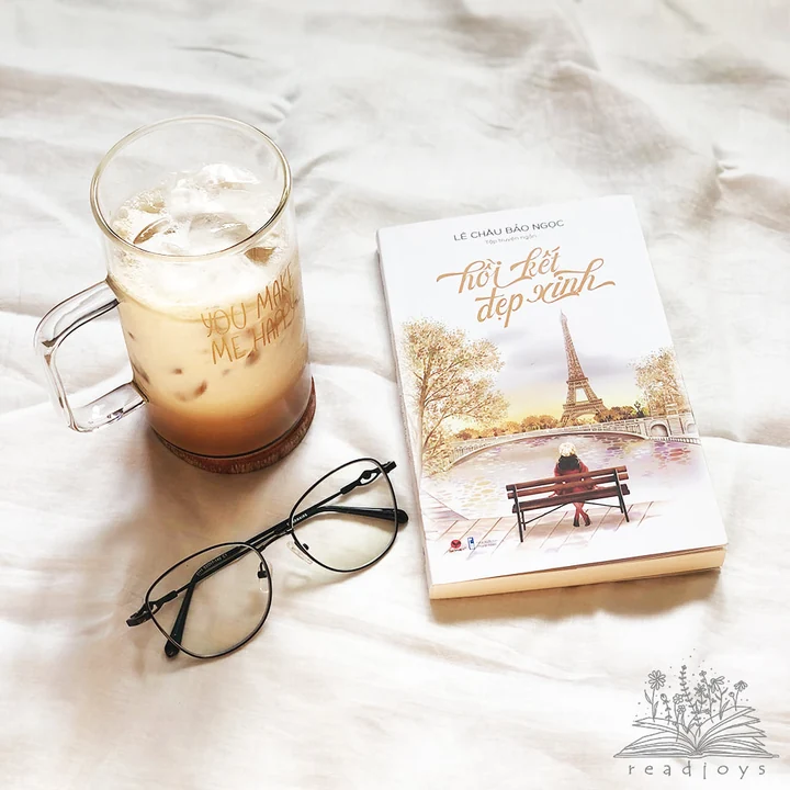 The book beside a drink and glasses, with the original readjoys watermark visible