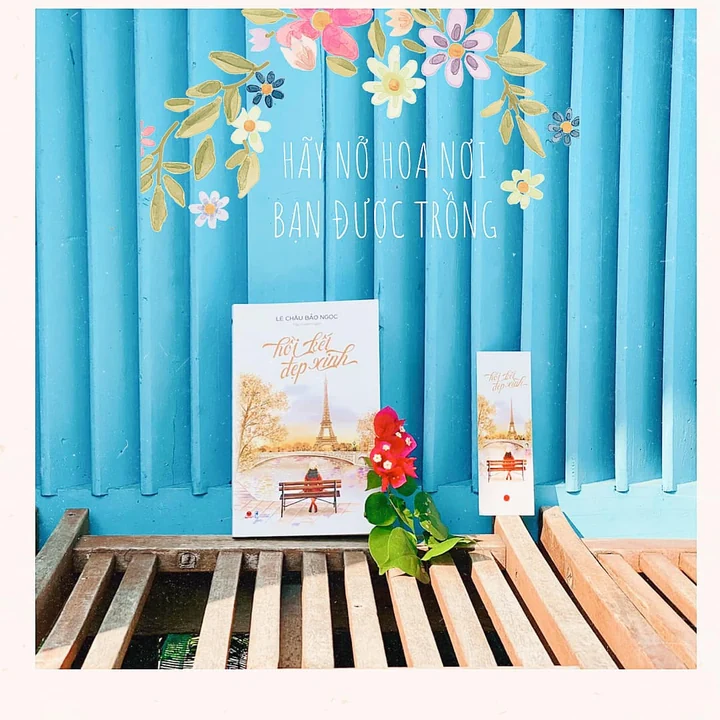 Hồi Kết Đẹp Xinh and a matching bookmark beside a flower against a blue shutter
