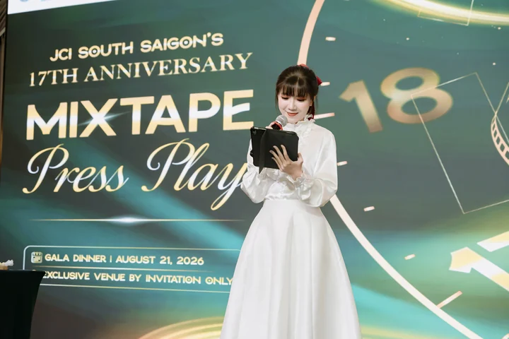 Christy hosting in front of a JCI South Saigon anniversary backdrop