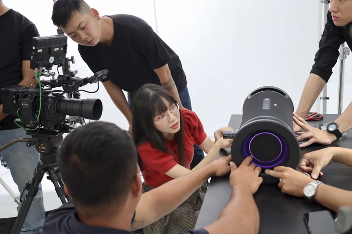 Christy and the production crew gathered around a Sony speaker beside the camera