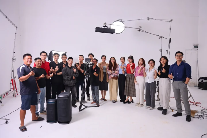 Production team standing together in a studio with speakers, cameras and lighting equipment