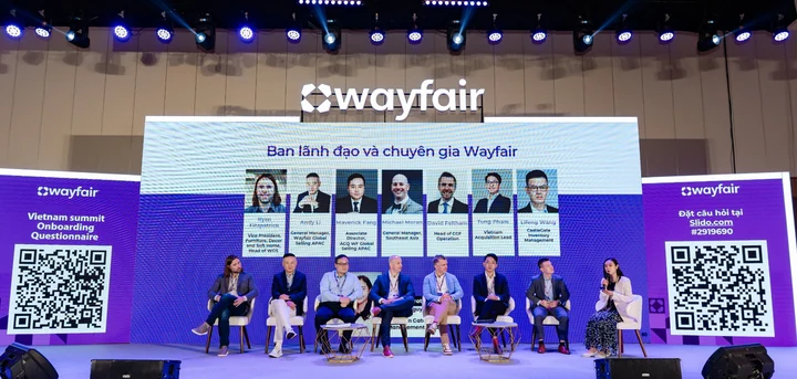 Panel discussion on a purple Wayfair conference stage